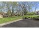 Landscaped backyard with green lawn, mature trees, shed, and concrete patio at 12867 Andover Dr, Carmel, IN 46033