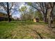 Picturesque backyard with mature trees, lush green lawn, and a charming storage shed, offering a serene outdoor space at 12867 Andover Dr, Carmel, IN 46033