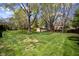 A view of the green backyard and shed surrounded by trees at 12867 Andover Dr, Carmel, IN 46033