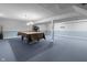 Spacious basement with blue carpet, exposed ceiling, pool table, and exercise equipment at 12867 Andover Dr, Carmel, IN 46033