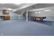 Large basement with blue carpet, drop ceiling, bar area, pool table, and stairs leading up at 12867 Andover Dr, Carmel, IN 46033