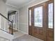 Bright foyer with a decorative glass front door, staircase, and neutral color palette at 12867 Andover Dr, Carmel, IN 46033