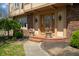 Close-up of a home's brick-lined front porch with planters on either side of the stained wood door at 12867 Andover Dr, Carmel, IN 46033