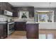 Kitchen featuring stainless steel appliances, stone countertops, and warm wood flooring at 12867 Andover Dr, Carmel, IN 46033