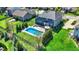 Aerial view of a backyard with a pool, a patio with a firepit, and manicured lawns at 13836 Fieldcrest Dr, McCordsville, IN 46055