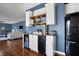 Charming bar area features custom cabinets, open shelving, and built in beverage cooler at 13836 Fieldcrest Dr, McCordsville, IN 46055