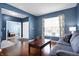 Comfortable living room with hardwood floors, natural light, and stylish blue walls at 13836 Fieldcrest Dr, McCordsville, IN 46055