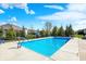 A refreshing in-ground pool complete with a basketball hoop is surrounded by a manicured lawn and mature trees at 13836 Fieldcrest Dr, McCordsville, IN 46055