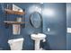 Stylish powder room with a pedestal sink, round mirror, and rustic shelving at 13836 Fieldcrest Dr, McCordsville, IN 46055
