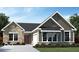 Charming single-story home featuring stone accents, dark siding, and a well-manicured lawn at 15053 Garden Mist Pl, Fishers, IN 46037