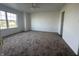 A spacious bedroom featuring a ceiling fan, large window, and neutral carpet at 1539 Egret Ln, Greenwood, IN 46143