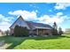 A view of the backyard with manicured lawn and covered patio area with seating at 16 Cattail Ln, Brownsburg, IN 46112