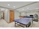 Basement recreational area with a ping pong table, workout equipment, and nearby doors at 16 Cattail Ln, Brownsburg, IN 46112