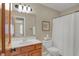 Bathroom with wood vanity, large mirror and a shower with white shower curtain at 16 Cattail Ln, Brownsburg, IN 46112