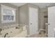 Bathroom featuring a window above the bathtub, tile backsplash and wood-look flooring at 16 Cattail Ln, Brownsburg, IN 46112