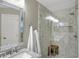Modern bathroom with a glass shower, neutral tile and a granite countertop with a decorative mirror at 16 Cattail Ln, Brownsburg, IN 46112
