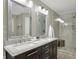 Bathroom featuring dual sinks, granite countertops, tiled shower and modern fixtures at 16 Cattail Ln, Brownsburg, IN 46112