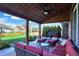 Inviting covered patio with comfortable seating, ceiling fan, overlooking landscaped backyard at 16 Cattail Ln, Brownsburg, IN 46112