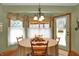 Sunlit dining area with hardwood floors and a round table at 16 Cattail Ln, Brownsburg, IN 46112