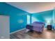 Bright bedroom with blue walls, wood floor, natural light, and a comfortable-looking bed at 18980 Bladed Mills Dr, Noblesville, IN 46062