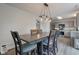 Dining room area view into the kitchen with seating for six and decorative lighting at 18980 Bladed Mills Dr, Noblesville, IN 46062