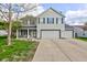 Charming two-story home features a two car garage, gray siding, and a covered front porch at 18980 Bladed Mills Dr, Noblesville, IN 46062