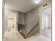 Bright hallway with tile floors featuring stair railing and doorways leading to rooms at 18980 Bladed Mills Dr, Noblesville, IN 46062