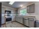 Modern kitchen with stainless steel appliances, gray cabinetry, and sleek countertops at 18980 Bladed Mills Dr, Noblesville, IN 46062