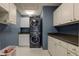 Convenient laundry room with a stacked washer and dryer and ample white cabinet storage at 18980 Bladed Mills Dr, Noblesville, IN 46062