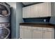 Functional laundry area with stacked washer/dryer and white cabinets for storage space at 18980 Bladed Mills Dr, Noblesville, IN 46062