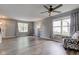 Inviting living room with light-colored walls, hardwood floors, a ceiling fan, and multiple windows at 18980 Bladed Mills Dr, Noblesville, IN 46062