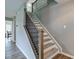 A modern staircase features wood steps, a black railing, and leads up to the second floor at 18980 Bladed Mills Dr, Noblesville, IN 46062