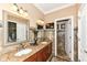 Bathroom featuring double sinks, granite countertops, decorative mirror, tile accent wall, and a doorway to water closet at 19311 Morrison Way, Noblesville, IN 46060