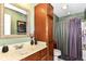 Compact bathroom with a single sink, vanity, combined shower and bathtub with purple curtain and green walls at 19311 Morrison Way, Noblesville, IN 46060