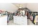 Large walk-in closet featuring center island with drawers, shelves, lots of storage, and a ceiling fan at 19311 Morrison Way, Noblesville, IN 46060