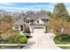 A charming home boasts a stone and brick facade, complemented by a well-manicured lawn and mature trees at 19311 Morrison Way, Noblesville, IN 46060