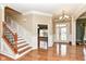 Elegant foyer with staircase, chandelier, hardwood floors, and abundant natural light at 19311 Morrison Way, Noblesville, IN 46060