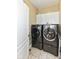 Functional laundry room with front loading washer and dryer set, white cabinets, and tile flooring at 19311 Morrison Way, Noblesville, IN 46060