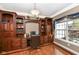 Home office with custom built-in wooden shelving, cabinets, and a large window for natural light at 19311 Morrison Way, Noblesville, IN 46060