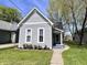 Charming home featuring gray siding, updated windows, and a well-maintained lawn with small garden bed at 2022 Indiana Ave, Columbus, IN 47201