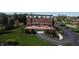 Aerial view of condo building with a rooftop terrace, lush landscaping, and parking at 20971 Shoreline Ct # 305, Noblesville, IN 46062