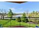 Balcony view of a lake and trees with a black metal railing and red concrete slab floor at 20971 Shoreline Ct # 305, Noblesville, IN 46062