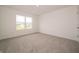 A bright bedroom with a large window, neutral carpet, and white walls, creating a serene atmosphere at 210 Aster Way, Greenfield, IN 46140