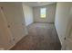 Bright, neutral-carpeted bedroom featuring natural lighting from a front-facing window and an attached door at 210 Aster Way, Greenfield, IN 46140