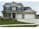 Charming two-story home featuring a two-car garage, manicured lawn, and a blend of brick and siding accents at 210 Aster Way, Greenfield, IN 46140