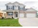 Charming two-story home with a manicured lawn, a two-car garage, and attractive brick and vinyl siding at 210 Aster Way, Greenfield, IN 46140