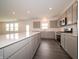 Kitchen with island, gray cabinets, stainless appliances, and view of living area at 210 Aster Way, Greenfield, IN 46140