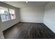 Bright, empty living room featuring luxury vinyl plank flooring and a large window, offering great natural light at 210 Aster Way, Greenfield, IN 46140