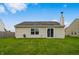 A view of a backyard on a sunny day with a house, grass and blue sky at 2138 Rossington Ln, Indianapolis, IN 46229