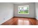 Sunlit bedroom with hardwood floors and a large window overlooking the backyard at 2138 Rossington Ln, Indianapolis, IN 46229